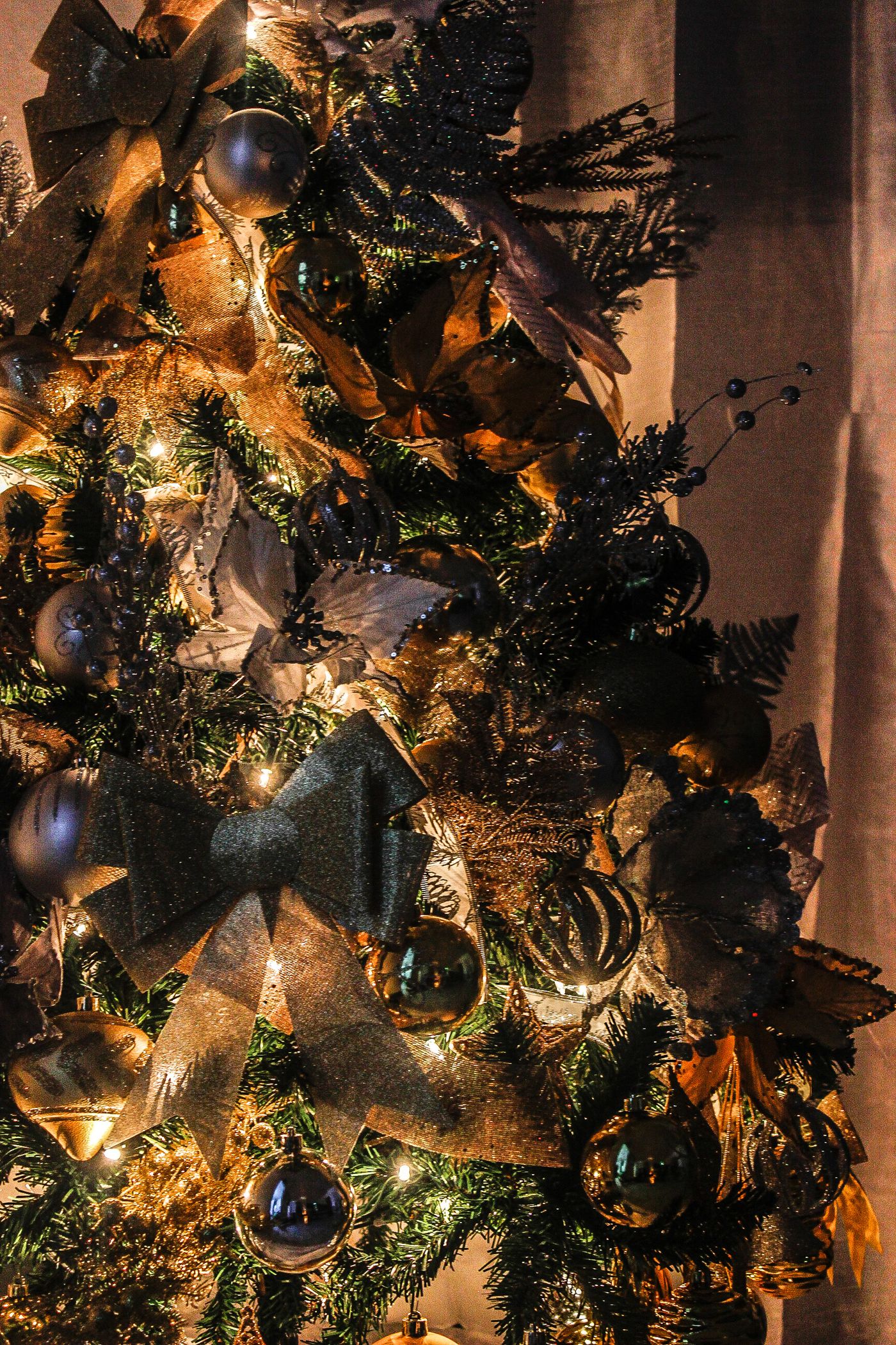 Close view of a decorated Christmas tree with lights and ribbons